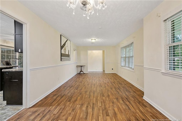 2547 Red Springs Rd, Raeford, NC 28376 - spare room with wood finished floors, a textured ceiling, a chandelier, and baseboards