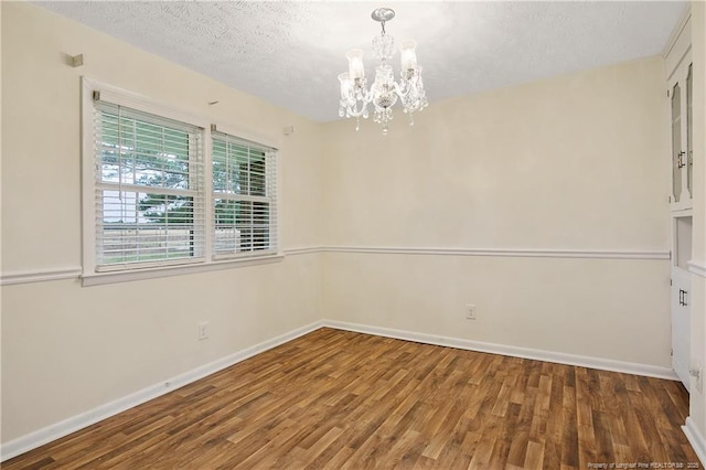 2547 Red Springs Rd, Raeford, NC 28376 - spare room featuring a chandelier, wood finished floors, baseboards, and a textured ceiling