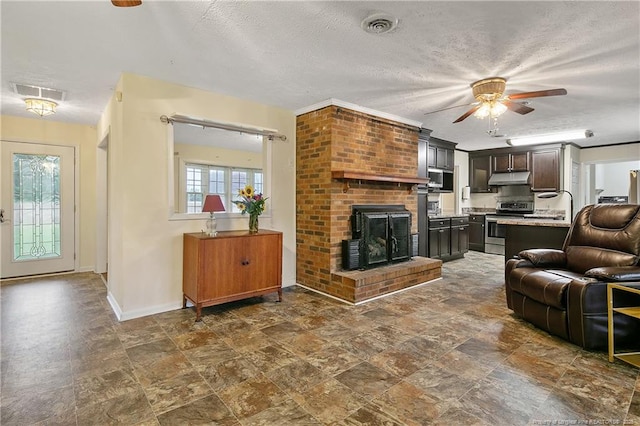 2547 Red Springs Rd, Raeford, NC 28376 - living room featuring ceiling fan, stone finish floors, baseboards, a brick fireplace, and a textured ceiling