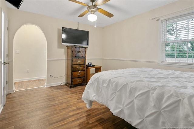 2547 Red Springs Rd, Raeford, NC 28376 - bedroom with wood finished floors, arched walkways, baseboards, and a ceiling fan