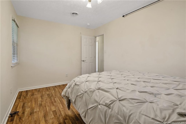 2547 Red Springs Rd, Raeford, NC 28376 - bedroom with wood finished floors, baseboards, and a textured ceiling
