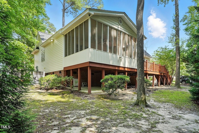 3020 Woods Walk Way, Rocky Mount, NC 27804 - rear view of property featuring a sunroom, stairway, brick siding, and a deck