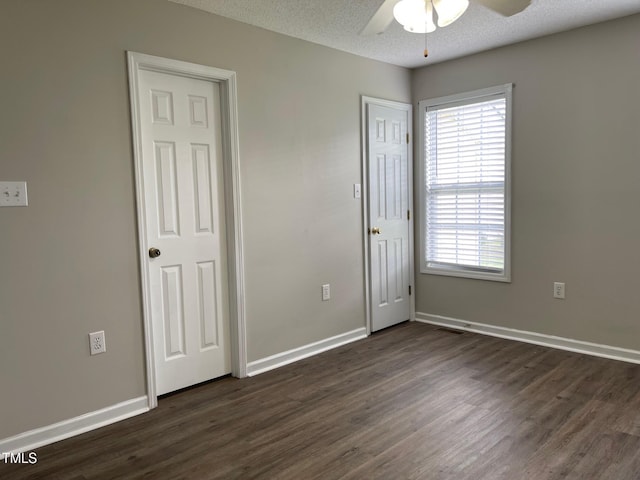 78 Ariel St, Lillington, NC 27546 - unfurnished bedroom with dark wood-style floors, multiple windows, baseboards, a textured ceiling, and ceiling fan