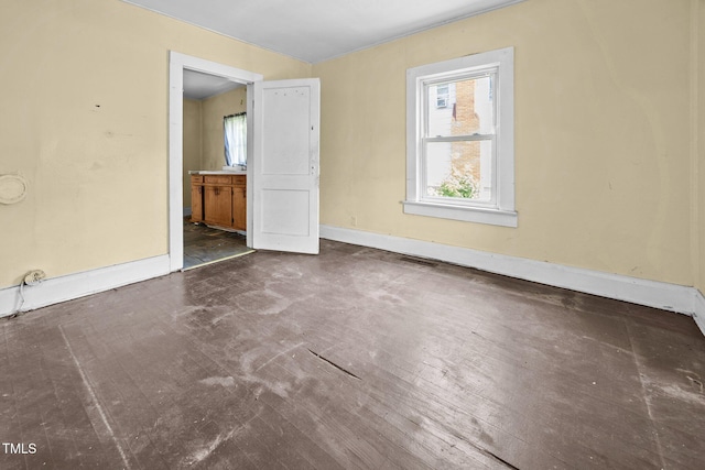 312 W Front St, Oxford, NC 27565 - unfurnished bedroom featuring multiple windows, baseboards, and connected bathroom