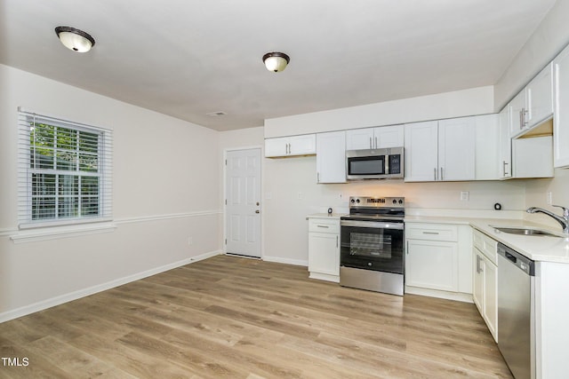 1110 Allgood St, Durham, NC 27704 - kitchen featuring stainless steel appliances, a sink, light countertops, light wood-style floors, and white cabinets