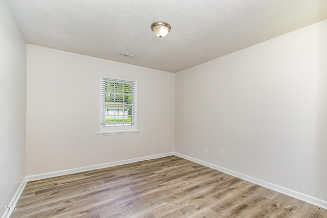 1110 Allgood St, Durham, NC 27704 - unfurnished room featuring light wood finished floors, baseboards, and a textured ceiling