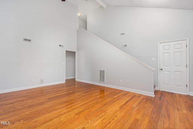 3306 Woodland Park Rd, Durham, NC 27703 - unfurnished living room featuring high vaulted ceiling, stairway, light wood-style floors, beamed ceiling, and baseboards
