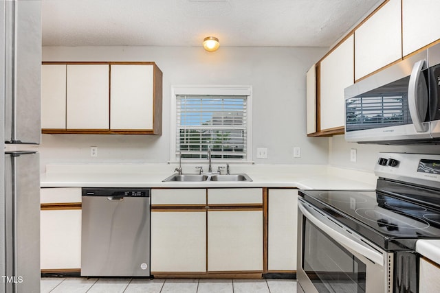 3306 Woodland Park Rd, Durham, NC 27703 - kitchen with stainless steel appliances, a sink, light countertops, a textured ceiling, and white cabinets