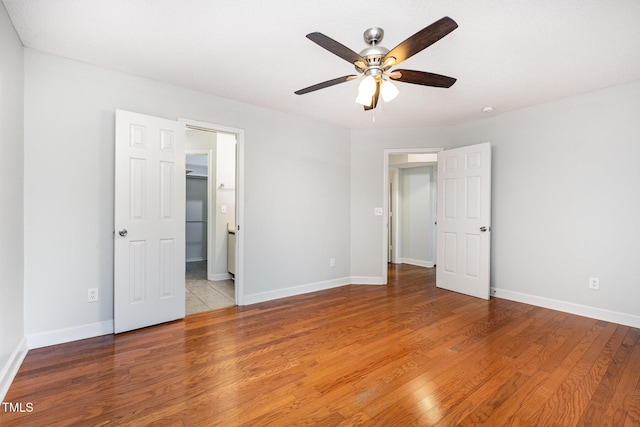 3306 Woodland Park Rd, Durham, NC 27703 - unfurnished bedroom with wood finished floors, baseboards, and a ceiling fan