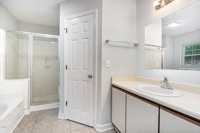 3306 Woodland Park Rd, Durham, NC 27703 - full bathroom featuring a shower stall, vanity, a garden tub, tile patterned flooring, and a textured ceiling