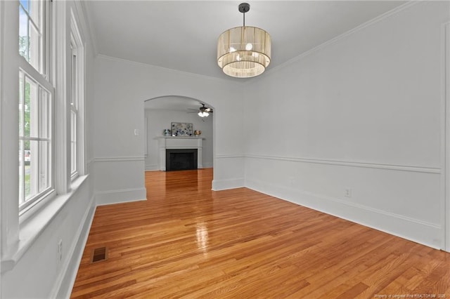 123 Ellington St, Fayetteville, NC 28305 - unfurnished room with light wood finished floors, arched walkways, a fireplace, crown molding, and a ceiling fan