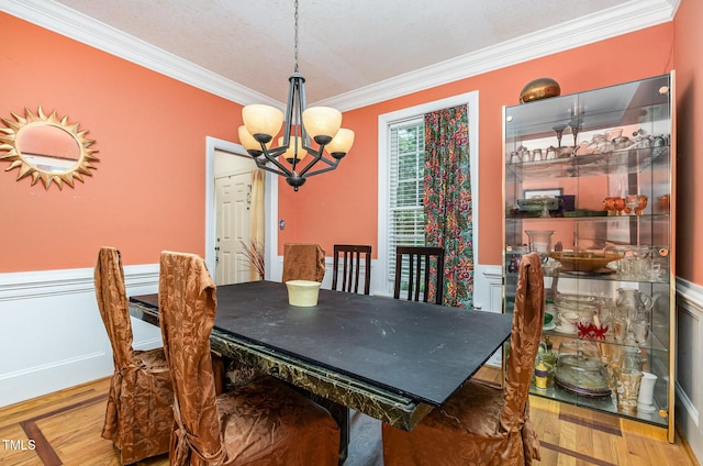 3304 Black Stallion Ct, Zebulon, NC 27597 - dining area with ornamental molding, a chandelier, wood finished floors, and wainscoting