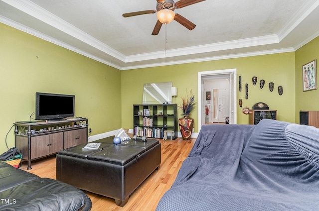 3304 Black Stallion Ct, Zebulon, NC 27597 - living area featuring light wood-type flooring, ornamental molding, ceiling fan, and a raised ceiling