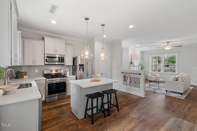 415 Dupree St, Durham, NC 27707 - kitchen featuring stainless steel appliances, a sink, a center island, a breakfast bar area, and backsplash