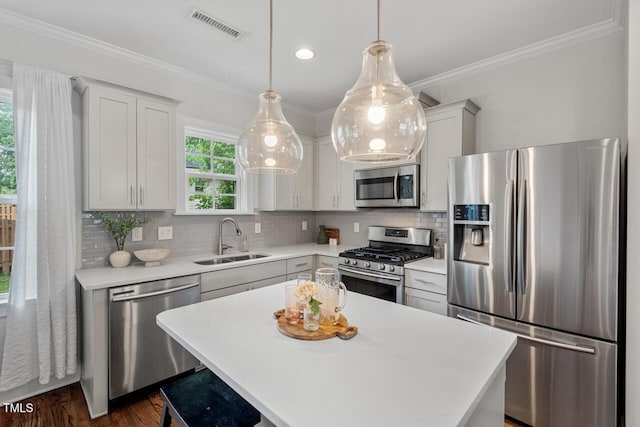 415 Dupree St, Durham, NC 27707 - kitchen featuring stainless steel appliances, a sink, light countertops, backsplash, and crown molding