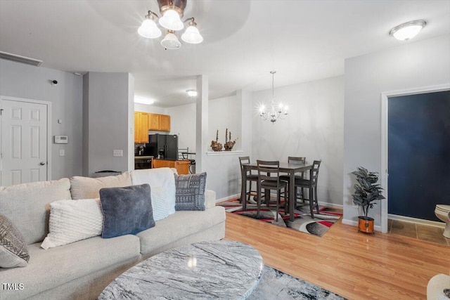 300 Gilman Ln Unit 101, Raleigh, NC 27610 - living area with light wood-style flooring, ceiling fan, a chandelier, and baseboards