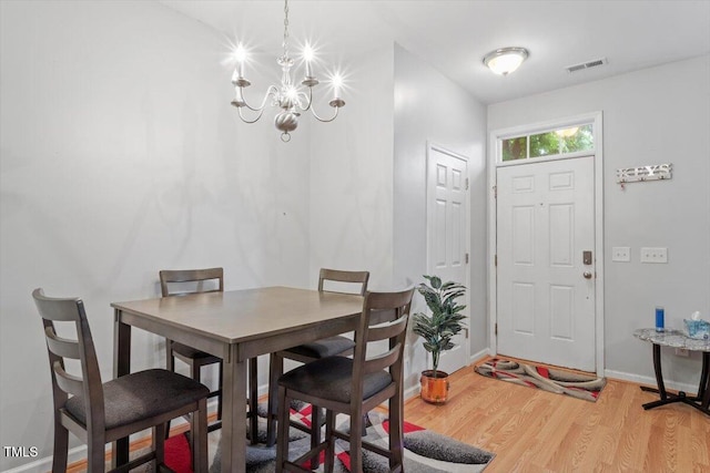 300 Gilman Ln Unit 101, Raleigh, NC 27610 - dining room with light wood-style flooring, a chandelier, and baseboards