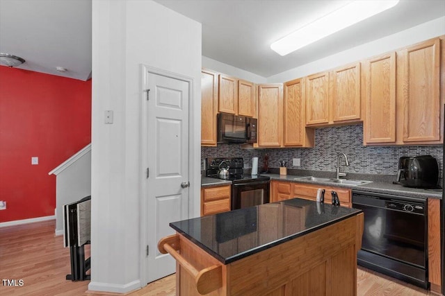 300 Gilman Ln Unit 101, Raleigh, NC 27610 - kitchen with black appliances, a sink, decorative backsplash, light wood-style floors, and a kitchen island