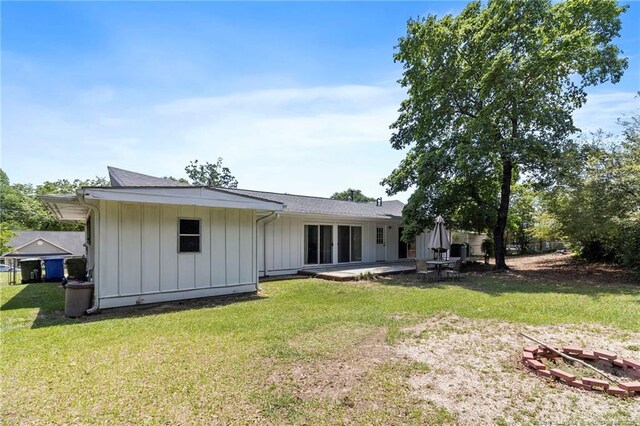 1926 Martindale Dr, Fayetteville, NC 28304 - rear view of house with board and batten siding, a yard, and a patio area