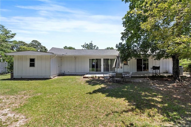 1926 Martindale Dr, Fayetteville, NC 28304 - rear view of house with board and batten siding, a lawn, and a patio