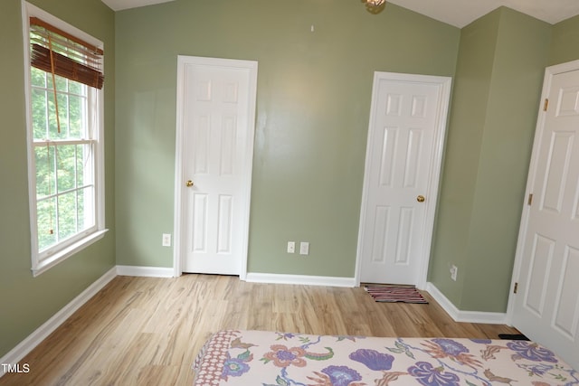 114 Calebra Way, Cary, NC 27519 - unfurnished bedroom with multiple windows, baseboards, and light wood finished floors