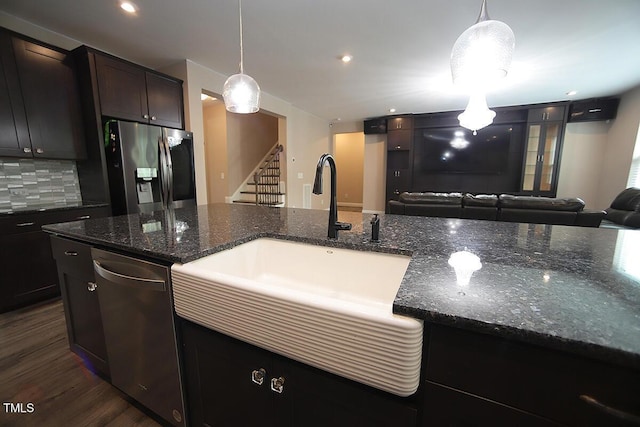 4416 Walker Hallow St, Raleigh, NC 27616 - kitchen featuring appliances with stainless steel finishes, backsplash, open floor plan, dark stone countertops, and dark wood finished floors