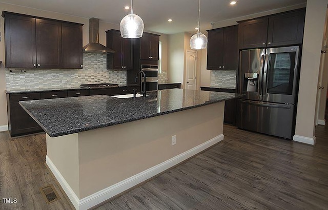 4416 Walker Hallow St, Raleigh, NC 27616 - kitchen featuring stainless steel appliances, wall chimney exhaust hood, dark wood-style floors, an island with sink, and dark brown cabinets