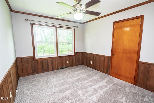 205 N Augusta Ave, Benson, NC 27504 - empty room featuring wainscoting, wooden walls, carpet, ornamental molding, and ceiling fan