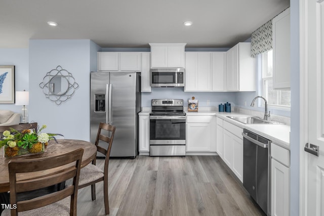 220 Gianna Dr, Lillington, NC 27546 - kitchen featuring stainless steel appliances, a sink, light countertops, white cabinets, and recessed lighting