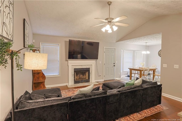 119 Proclamation Dr, Raeford, NC 28376 - living area with a textured ceiling, dark wood-style floors, vaulted ceiling, a ceiling fan, and a premium fireplace