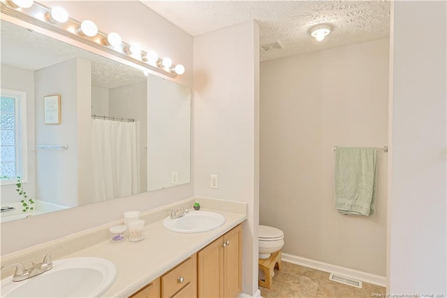 119 Proclamation Dr, Raeford, NC 28376 - bathroom featuring toilet, double vanity, a textured ceiling, baseboards, and a shower with curtain