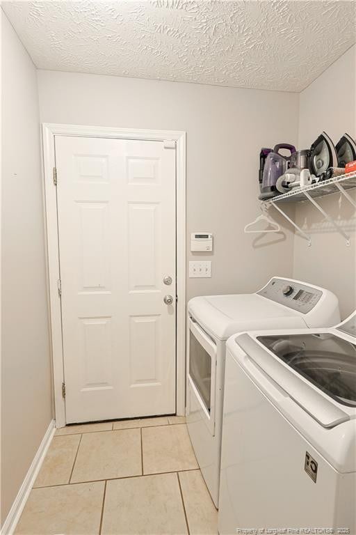 119 Proclamation Dr, Raeford, NC 28376 - laundry area featuring washer and dryer, light tile patterned floors, and a textured ceiling