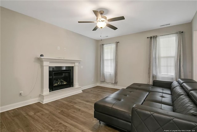 1664 Seattle Slew Ln, Hope Mills, NC 28348 - living room featuring a ceiling fan, wood finished floors, baseboards, and a glass covered fireplace