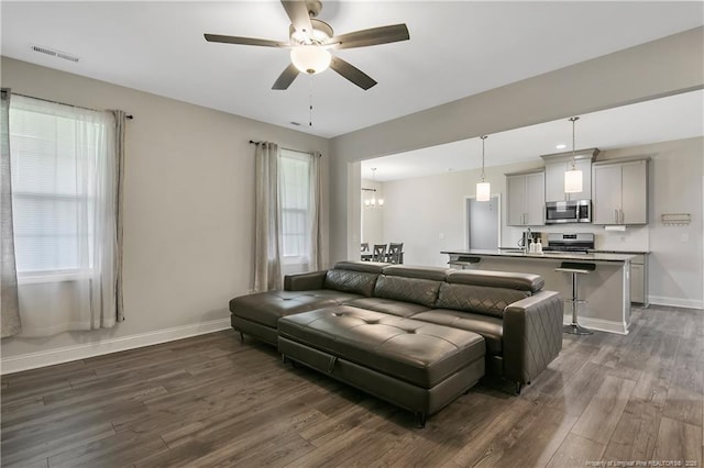 1664 Seattle Slew Ln, Hope Mills, NC 28348 - living area featuring a ceiling fan, dark wood finished floors, baseboards, and a chandelier
