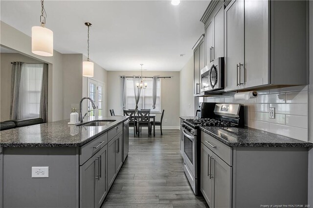 1664 Seattle Slew Ln, Hope Mills, NC 28348 - kitchen featuring appliances with stainless steel finishes, gray cabinetry, a sink, and dark wood-type flooring
