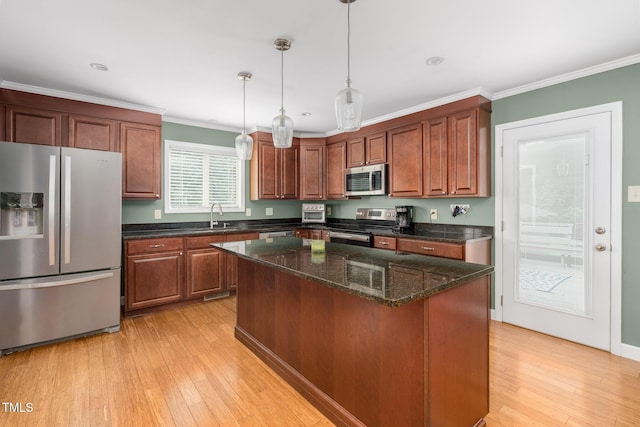 1822 Routh Rd, Burlington, NC 27217 - kitchen with stainless steel appliances, a sink, light wood-style floors, pendant lighting, and ornamental molding