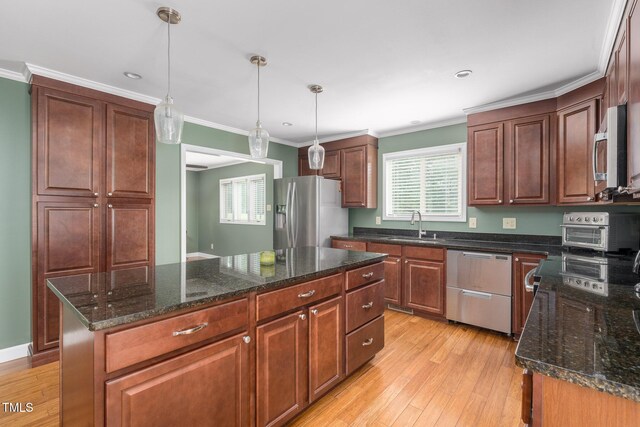 1822 Routh Rd, Burlington, NC 27217 - kitchen with appliances with stainless steel finishes, a sink, light wood-style floors, crown molding, and decorative light fixtures