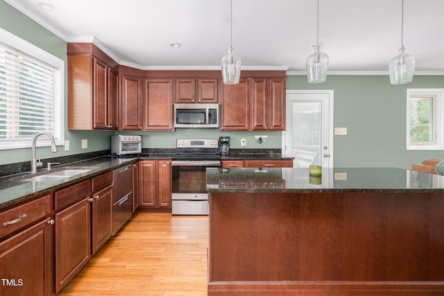 1822 Routh Rd, Burlington, NC 27217 - kitchen with stainless steel appliances, a sink, light wood-style flooring, pendant lighting, and ornamental molding