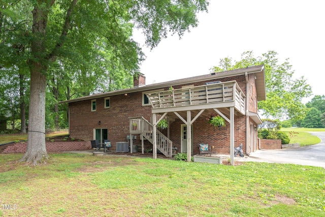 1822 Routh Rd, Burlington, NC 27217 - rear view of property with brick siding, central AC, a yard, and a chimney
