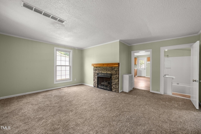 2527 Ossipee Front St, Elon, NC 27244 - unfurnished living room featuring crown molding, a textured ceiling, carpet floors, a fireplace, and baseboards