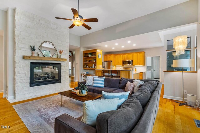 8821 Oconee Ct, Chapel Hill, NC 27516 - living area with a ceiling fan, light wood finished floors, a chandelier, a fireplace, and baseboards