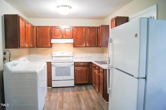 2626 Crestline Ave, Raleigh, NC 27603 - kitchen featuring white appliances, under cabinet range hood, washing machine and dryer, wood finished floors, and light countertops
