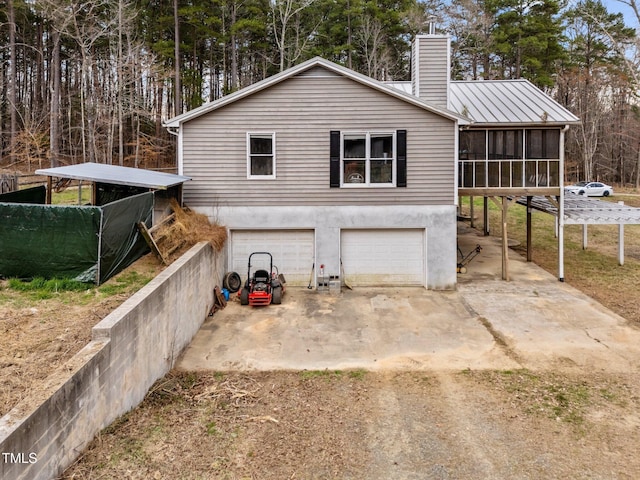 501 Enon Rd, Oxford, NC 27565 - rear view of property featuring dirt driveway, an attached garage, a sunroom, and a chimney