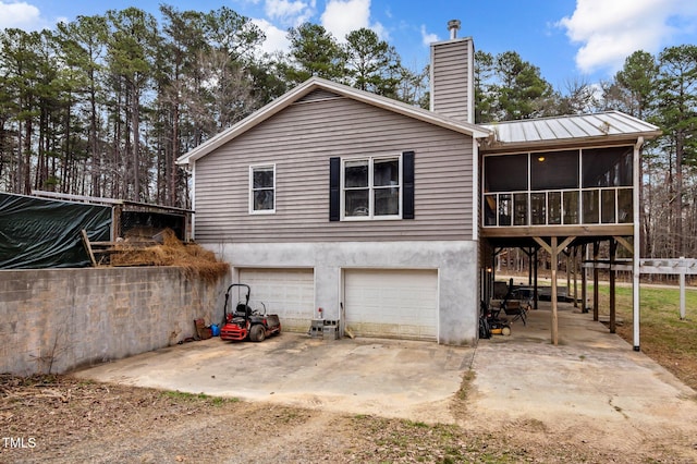 501 Enon Rd, Oxford, NC 27565 - back of house with driveway, an attached garage, a chimney, a sunroom, and metal roof