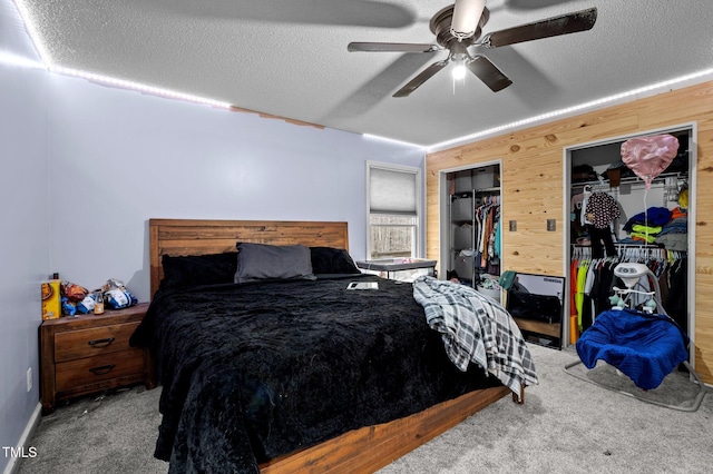 501 Enon Rd, Oxford, NC 27565 - carpeted bedroom with a textured ceiling, a ceiling fan, multiple closets, and wood walls