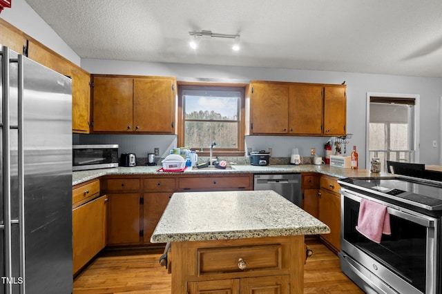 501 Enon Rd, Oxford, NC 27565 - kitchen featuring stainless steel appliances, a sink, light wood-style floors, healthy amount of natural light, and a textured ceiling