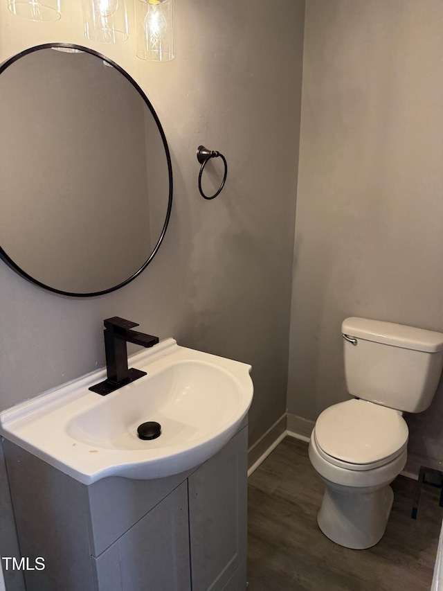 3825 Old Coach Rd, Raleigh, NC 27616 - half bath with vanity, toilet, wood finished floors, and baseboards