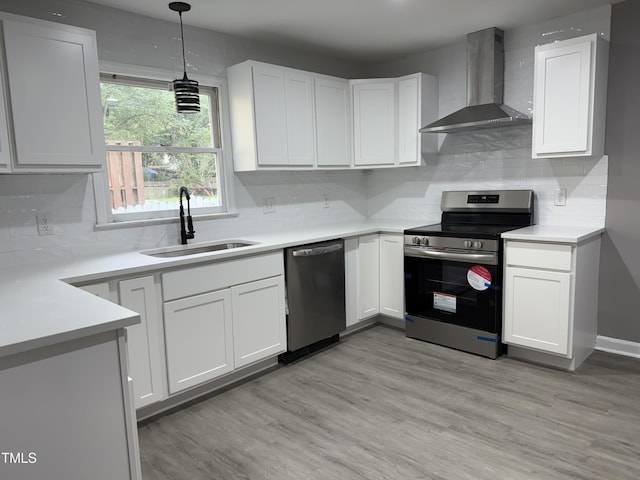 3825 Old Coach Rd, Raleigh, NC 27616 - kitchen featuring stainless steel appliances, wall chimney range hood, a sink, and white cabinetry