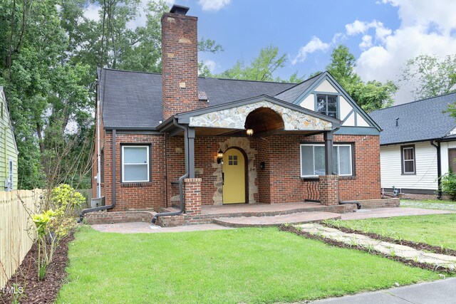 106 E Club Blvd, Durham, NC 27704 - tudor home featuring a chimney, brick siding, and stone siding