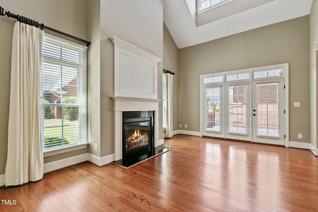 3628 Eagle Farm Dr N, Wilson, NC 27896 - unfurnished living room featuring high vaulted ceiling, light wood-style flooring, a premium fireplace, and baseboards